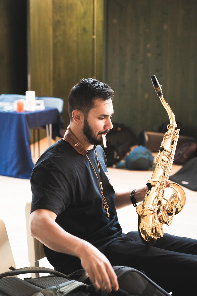 A jazz tenor saxophone musician preparing his instrument